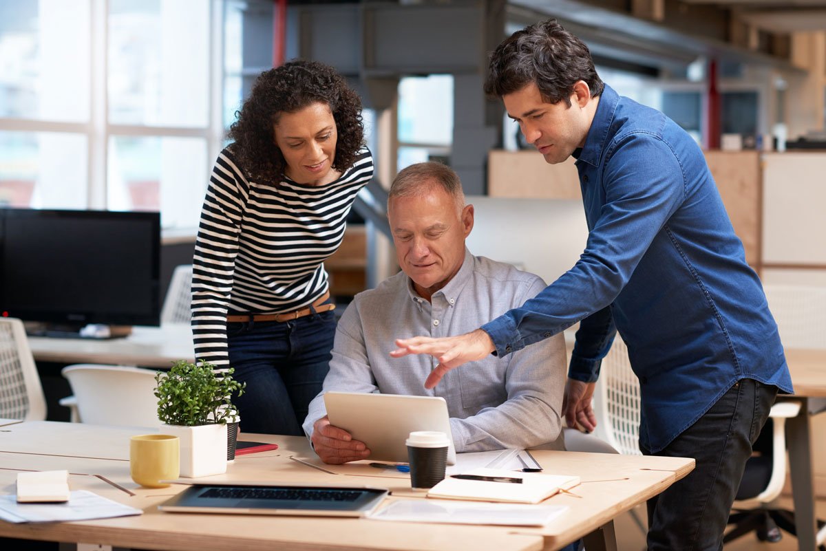 three family members discuss paperwork at a desk