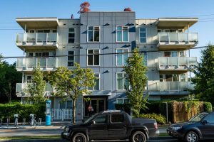 large residential apartment building on street with trees